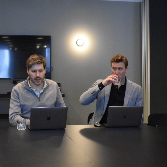 A picture of 2 men at laptops