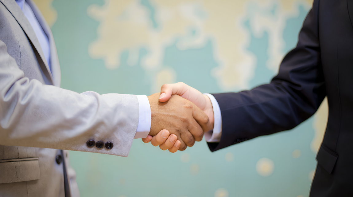 A photo of two men in suits shaking hands